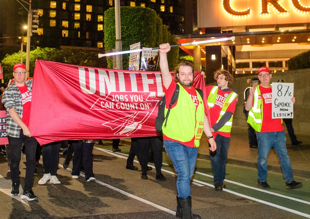 Striking workers march past Crown Casino shortly before