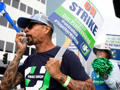 Rolando Escobar, right, a registered nurse, blows a horn during the strike in front of the Kaiser Permanente Los Angeles Medical Center on Monday, February 9, 2026, in Los Angeles, California.