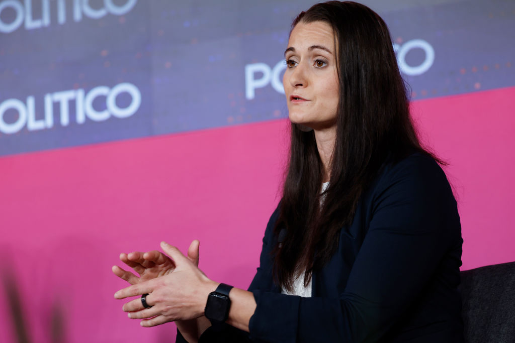 Cait Conley speaking in an interview with a background reading Politico.