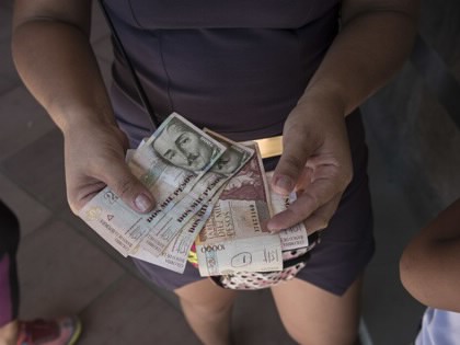 A woman receives Colombian pesos in exchange for Venezuelan bolivars after the reopening of the borders in Cúcuta, Colombia, on Tuesday, December 20, 2016.