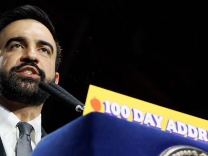 Mayor Zohran Mamdani speaking at a podium with a sign that says, "100 Day Address."