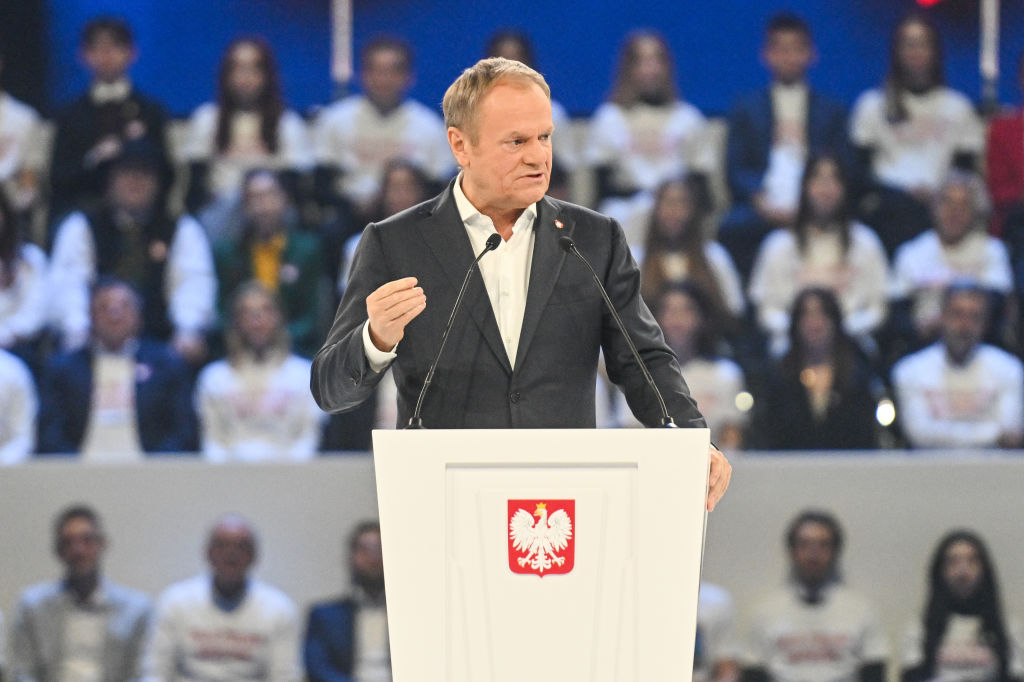 Poland’s Donald Tusk standing at a podium speaking to a crowd.