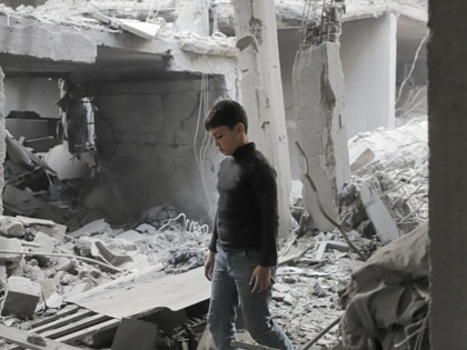 A boy walks through the rubble of a residential block in Al-Shati refugee camp west of Gaza City on May 9, 2026, 