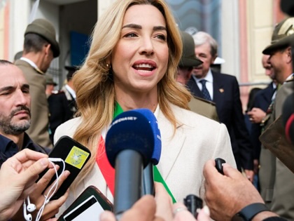 Silvia Salis speaking with microhones held up to her.