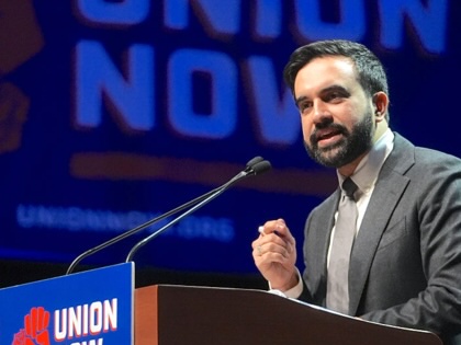Zohran Mamdani speaking at a podium that reads, "Union Now."