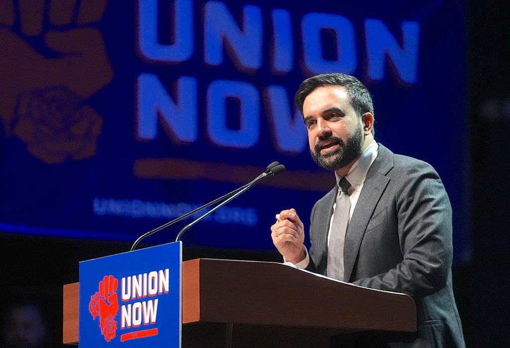 Zohran Mamdani speaking at a podium that reads, "Union Now."