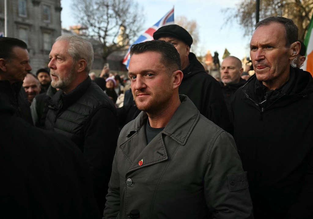 Tommy Robinson standing in a crowd on the street.