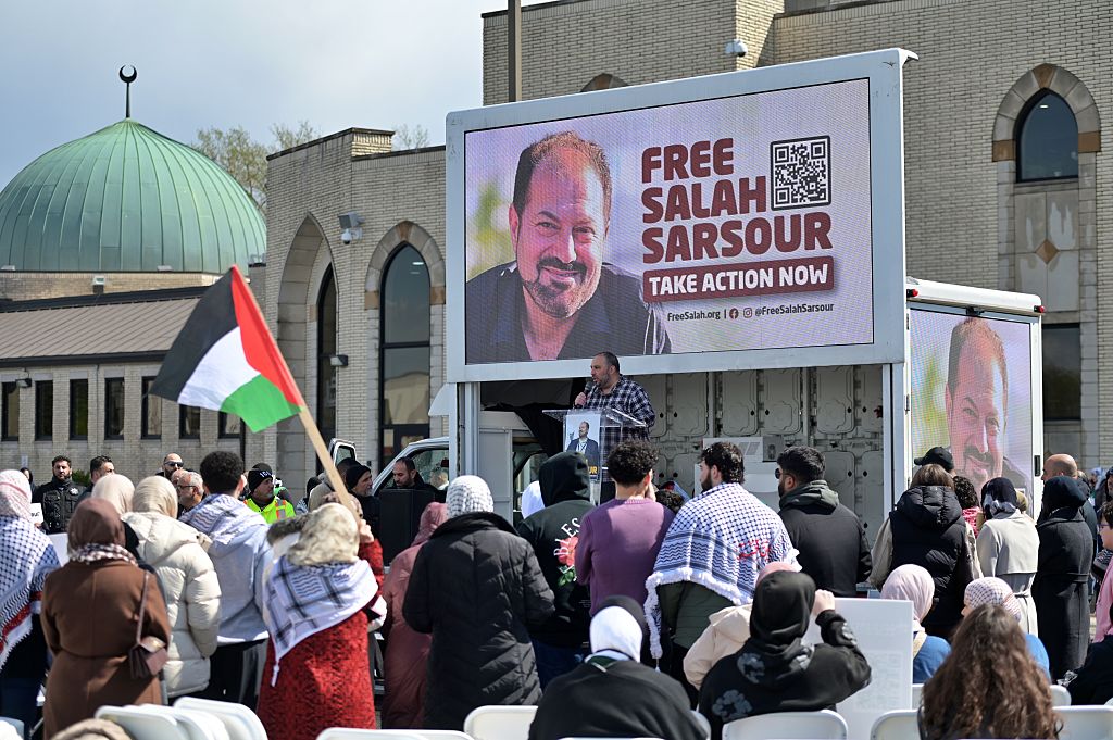 People, a holding portrait of Salah Sarsour, gather outside the Mosque Foundation to demand the release of Sarsour, the president of the Milwaukee Islamic Society and a prominent Palestinian American community leader, who was detained by US Immigration and Customs Enforcement (ICE) agents on March 30, in Bridgeview, Illinois, on April 19, 2026.