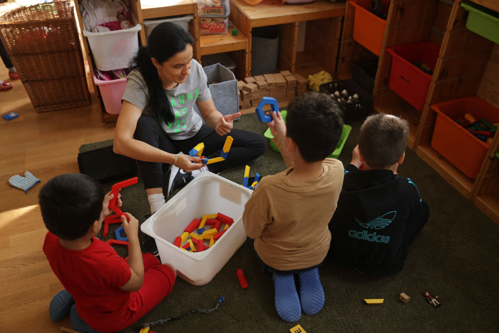 A teacher plays with children at the Kleiner Fratz daycare center in Berlin, Germany.