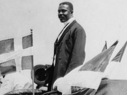 David Hamilton Jackson, founder of the Sankt Croix Labour Union, in Sankt Croix, standing in a car in the Danish West Indies, circa 1915. His car is flying the flag of Denmark.