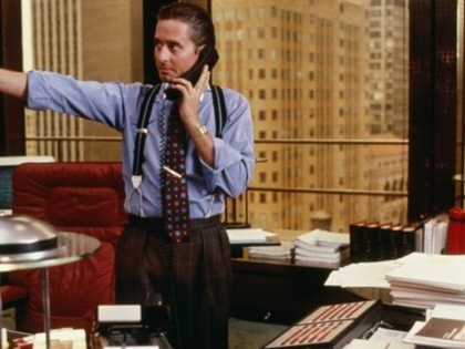 Still from Wall Street with Michael Douglas's character pointing while on the phone in an office.