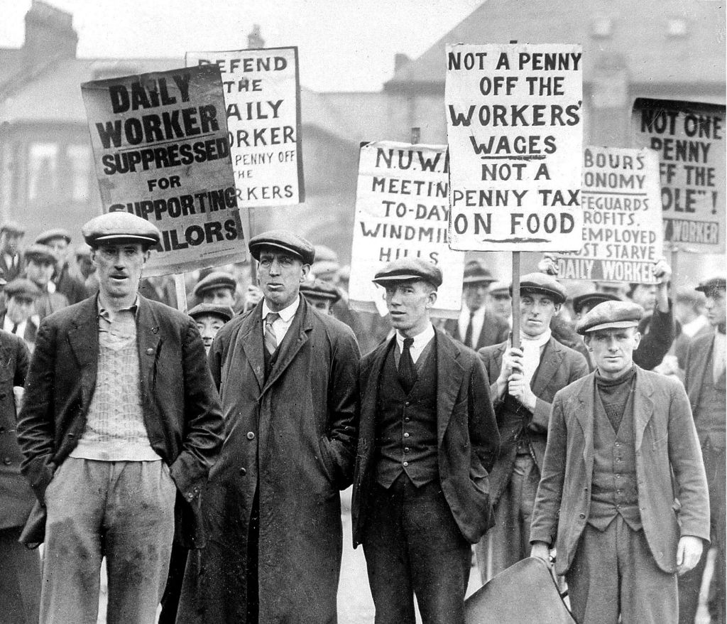 A group of workers holding up placards, one reading, "Not a penny off the workers' wages not a penny tax on food."