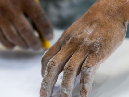 A stone countertop fabricator’s hands are covered in dust at a shop on Tuesday, October 31, 2023, in Sun Valley, California.