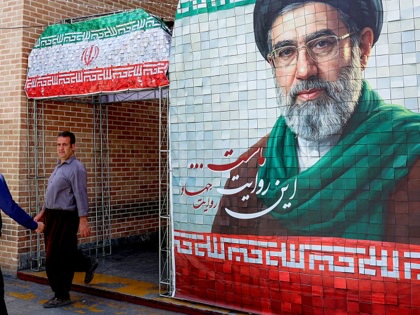 A man walks past a banner depicting Iran's current supreme leader Ayatollah Mojtaba Khamenei along a street Tehran on May 6, 2026.