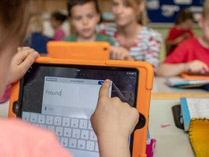 German children use tablets in primary school classroom. 