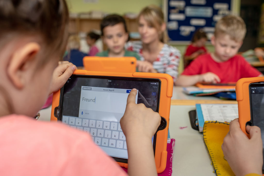 German children use tablets in primary school classroom.
