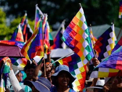 Indigenous women wave Wiphala flags during the celebrations marking the Day of the Plurinational State, in the town of Lauca Ene, Shinaota, Bolivia, on January 23, 2026.