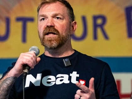 Graham Platner gesturing while speaking into a microphone.