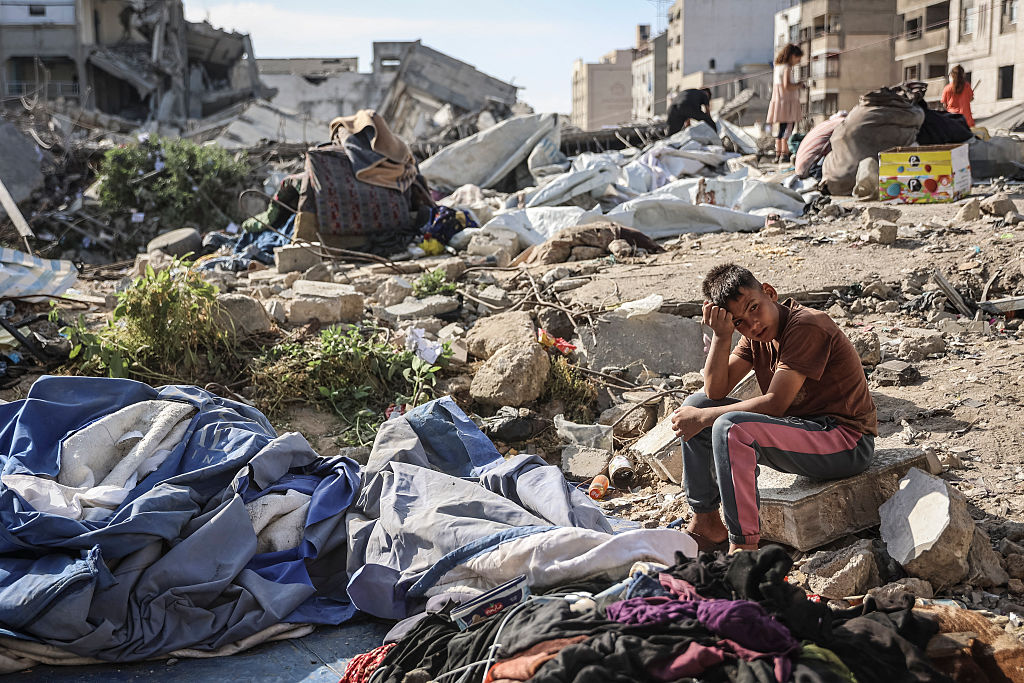 A Palestinian boy sits at the site of an overnight Israeli military strike on structures and tents housing displaced families, killing ten Palestinians, in Gaza City on May 28, 2026.