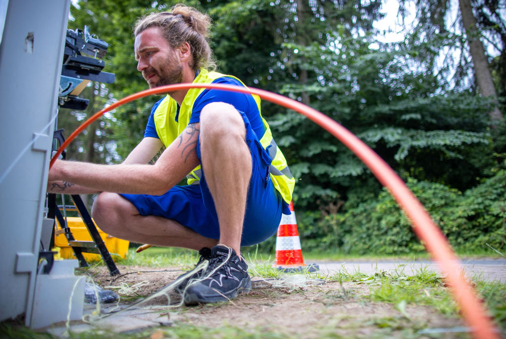 A German technician prepares a fiber optic cable for broadband internet expansion. 