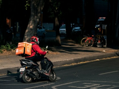 App delivery worker rides scooter in Mexico