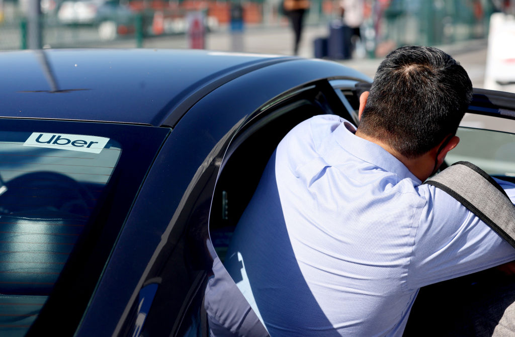 A man gets into an Uber. 