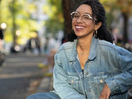 Darializa Avila Chevalier, sitting on a park bench and smiling.