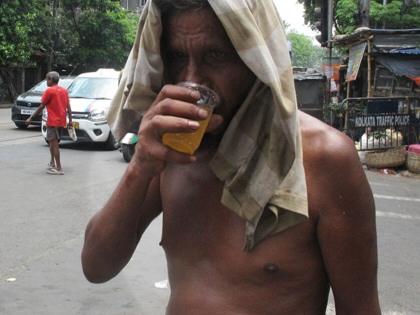 People cool off with a glass of cold water by the roadside amid a severe heat wave in Kolkata, India, on June 8, 2026.