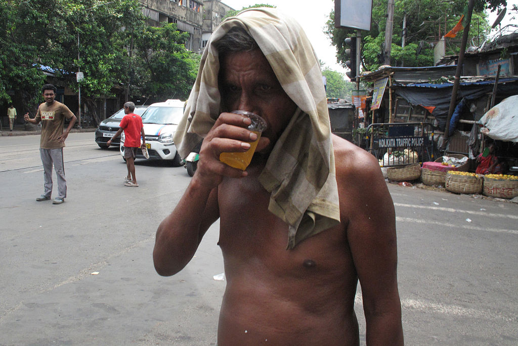 People cool off with a glass of cold water by the roadside amid a severe heat wave in Kolkata, India, on June 8, 2026.