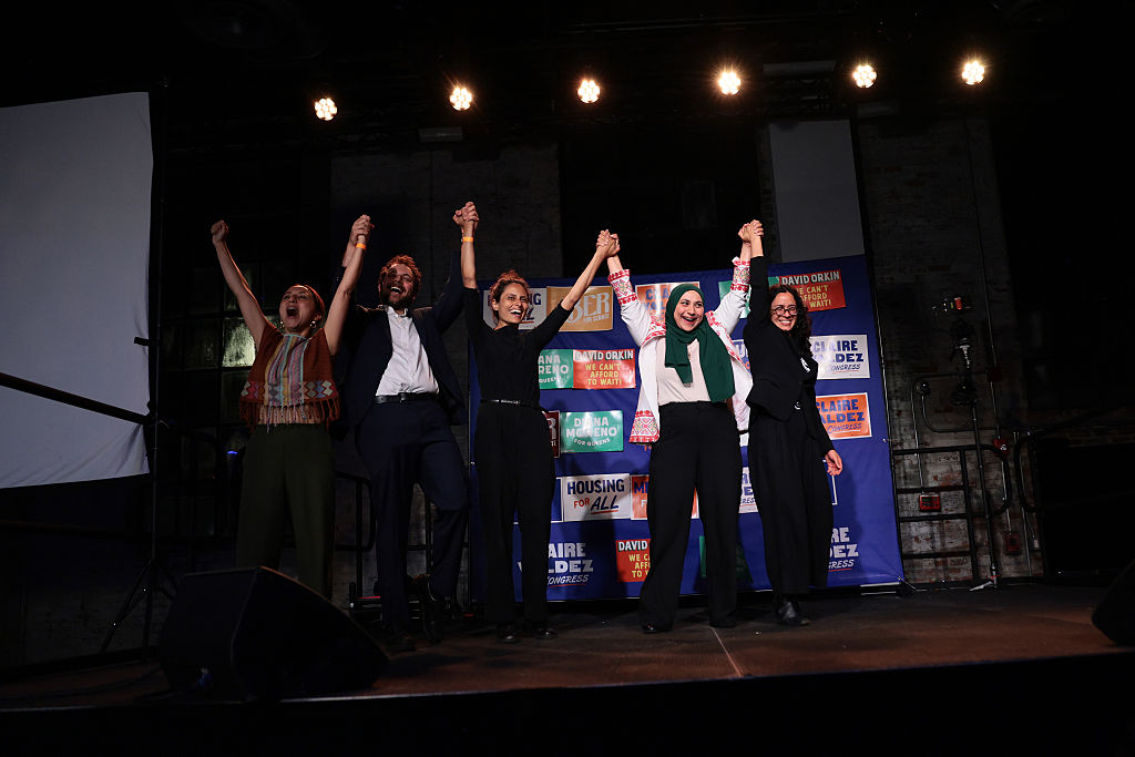 Diana Moreno, David Orkin, Samantha Kattan, Aber Kawas, and Claire Valdez raise their hands during a primary-night watch party at 99 Scott Studio on June 23, 2026, in the East Williamsburg neighborhood of Brooklyn in New York City. 