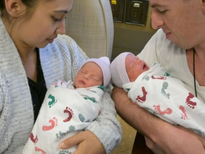 Parents hold their newborn twin children in Long Beach, California, 2023