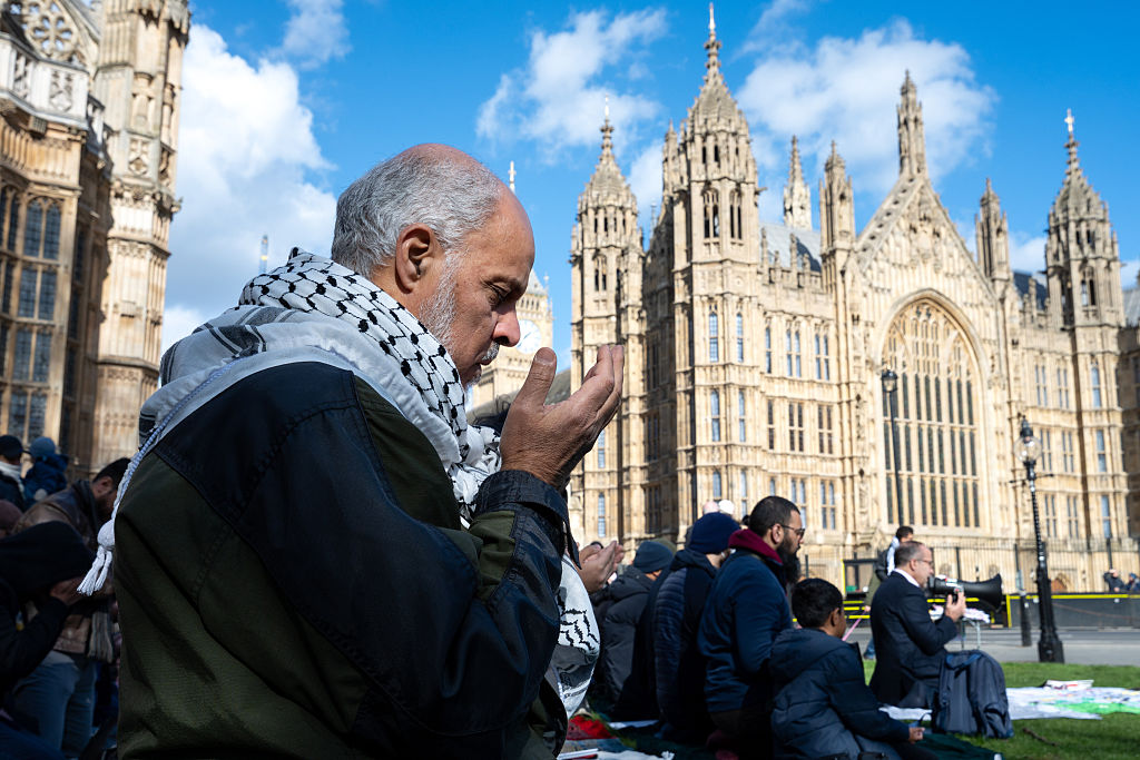 A protester in London, UK, performs a Dhuhr prayer with the House of Parliament and Elizabeth Tower in the background. 