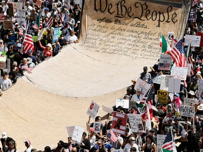 Protesters carry a banner representing the preamble to the US Constitution in Downtown Los Angeles during a “No Kings Day” demonstration against Donald Trump on June 14, 2025.