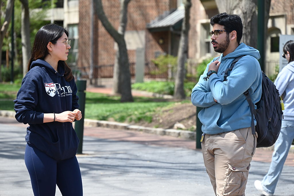 Two students speak on the campus of the University of Pennsylvania, in Philadelphia. 
