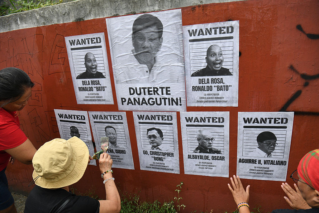 Relatives of drug suspects, who were allegedly illegally killed under orders from former Philippine president Rodrigo Duterte, post portraits of Duterte and his alleged coperpetrators during a rally along a street in Manila on March 11, 2026.