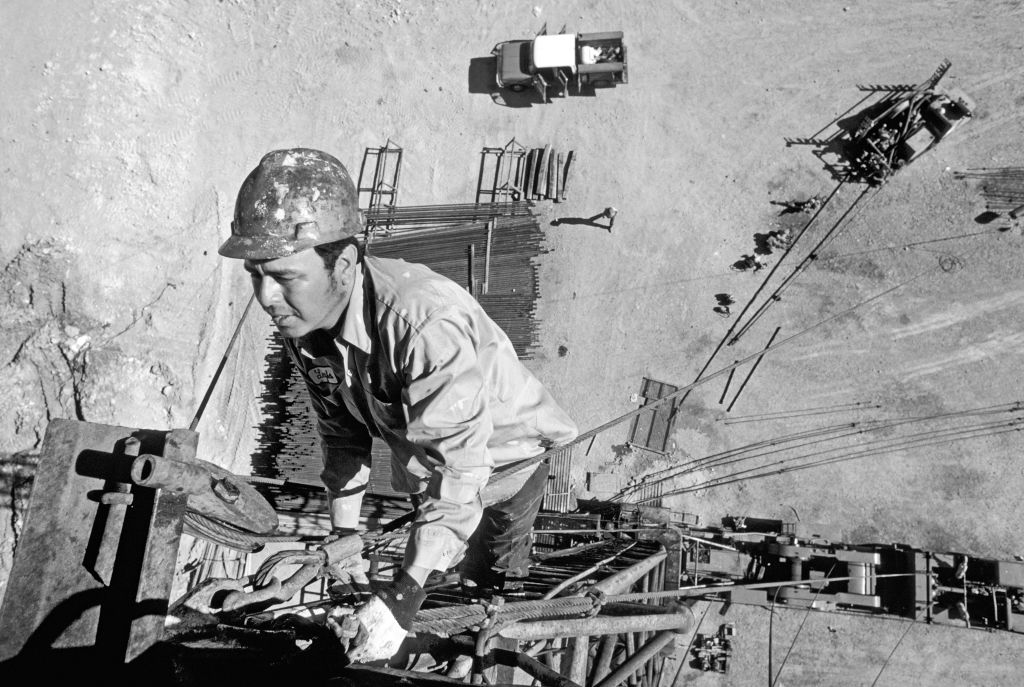 A roughneck oil worker works atop a wildcat oil drilling rig without safety equipment in the oll fields of southeast New Mexico, 1978.