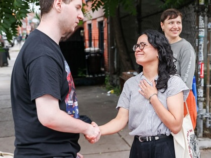 Claire Valdez speaks with voters outside a polling location at PS 84 during a primary election in New York on June 23, 2026.