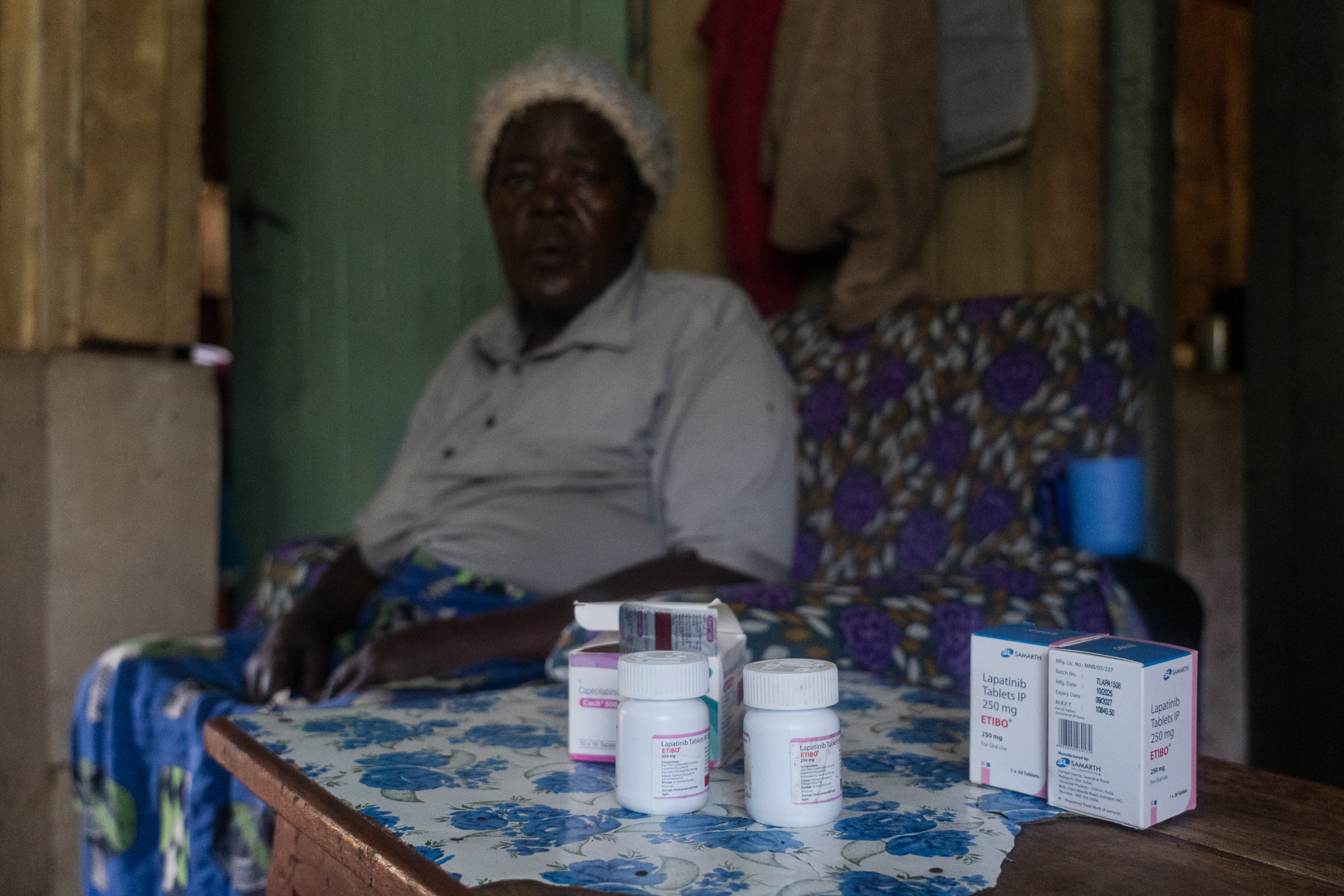 Kenyan farmer Rosaria Rigiri photographed with her medications in the foreground