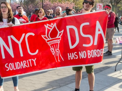 People protest during a 2018 May Day rally in Washington Square Park in New York City.