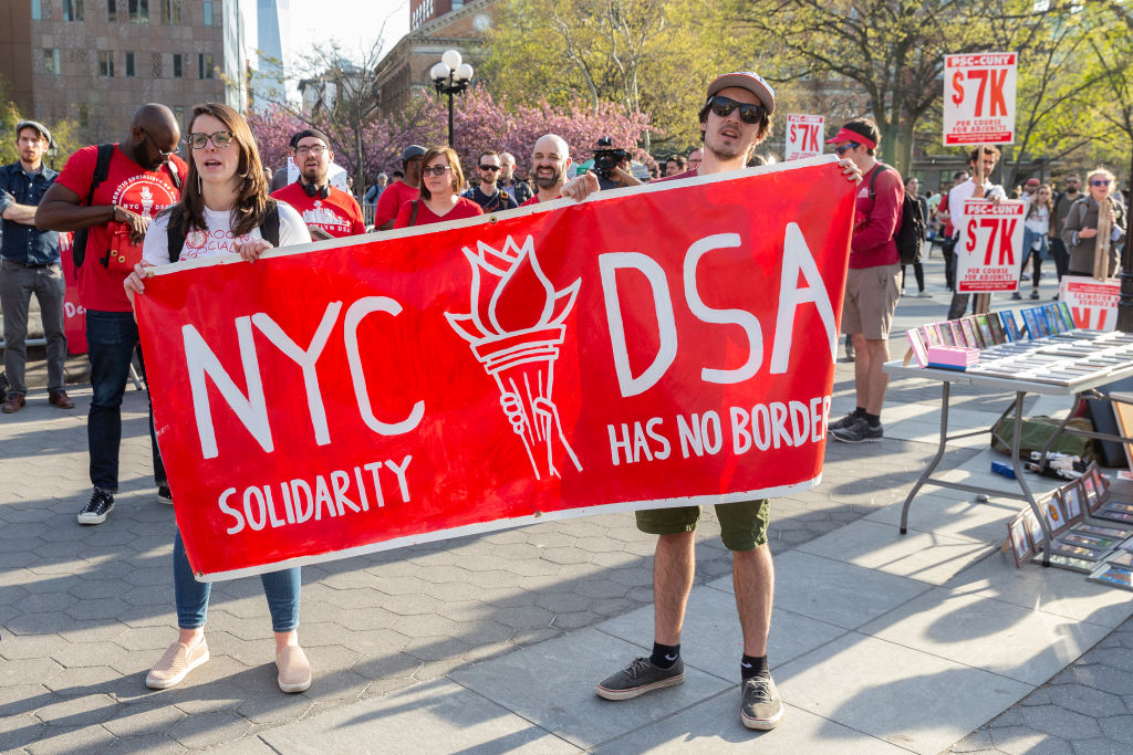 People protest during a 2018 May Day rally in Washington Square Park in New York City.