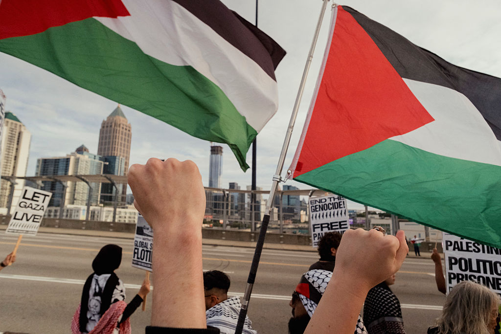 Demonstrators wave Palestinian flags during a Gaza solidarity rally at the 17th Street Bridge in Atlanta, Georgia, on October 4, 2025.