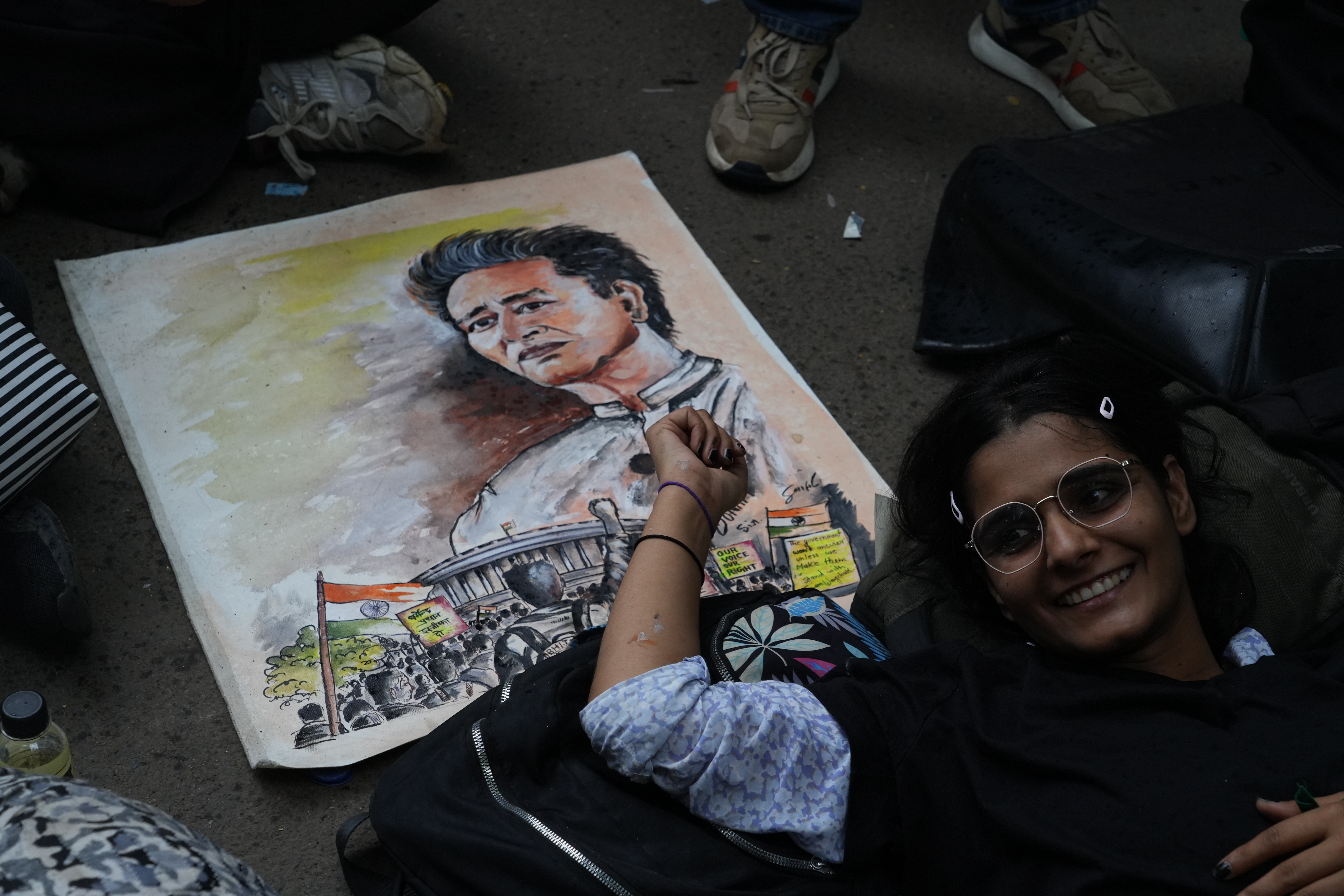 A student rests beside a picture of activist Sonam Wangchuk.
