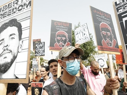 Protesters hold placards in support of Moroccan rapper El Mehdi Lyoubi, known professionally as Mehdi Black Wind, in front of the Ain Sebaa Court of First Instance where Lyoubi was appearing for a court hearing, in Casablanca on July 22, 2026.