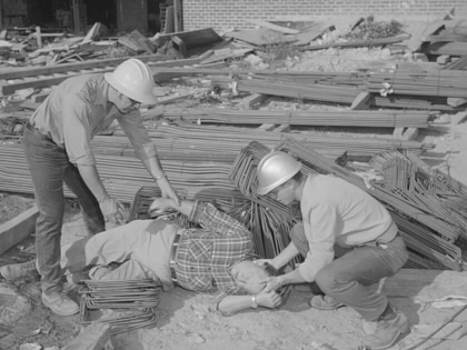 Archival photo: construction workers assist a coworker after an accident.