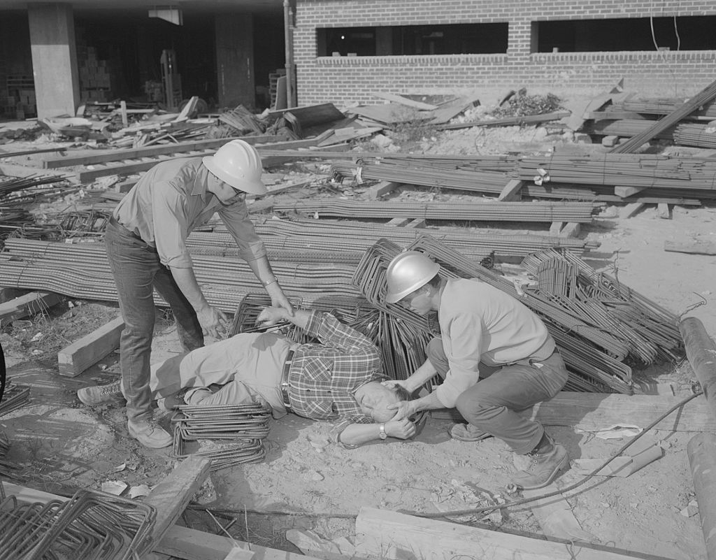 Archival photo: construction workers assist a coworker after an accident.