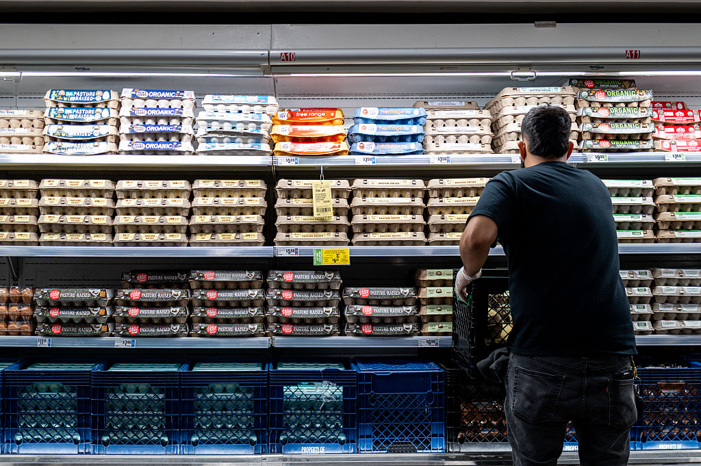 employee stocks eggs in supermarket
