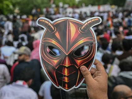 A Cockroach Janta Party supporter holds a cockroach mask during a protest in New Delhi on June 6, 2026. 