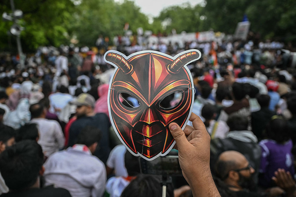 A Cockroach Janta Party supporter holds a cockroach mask during a protest in New Delhi on June 6, 2026. 