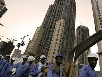 Migrant workers in the construction industry wait for their buses at the end of their working day on May 1, 2006, in Dubai, United Arab Emirates.