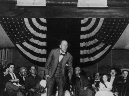 Eugene V. Debs addresses a crowd in front of an American flag.